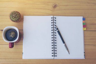 Üstten görünüm Not defteri kahve fincanı ve küçük kaktüs pot ahşap tablo