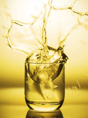 Sarı tonu splash su bir bardak yumuşak odak