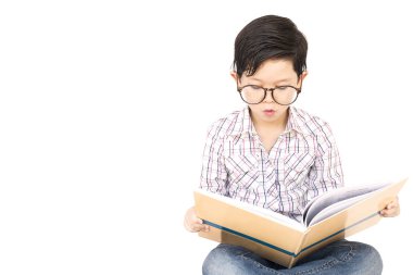 Yedi yıl yaşlı Asya çocuk heyecanla beyaz bitti izole bir kitap okuyor