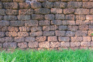 Eski granit tuğla taş dokulu arka plan kullanmak için yeşil çim ve duvar