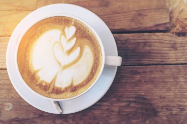 Vintage sıcak kahve fincanı güzel Latte sanat dekorasyon eski ahşap doku tablo ile