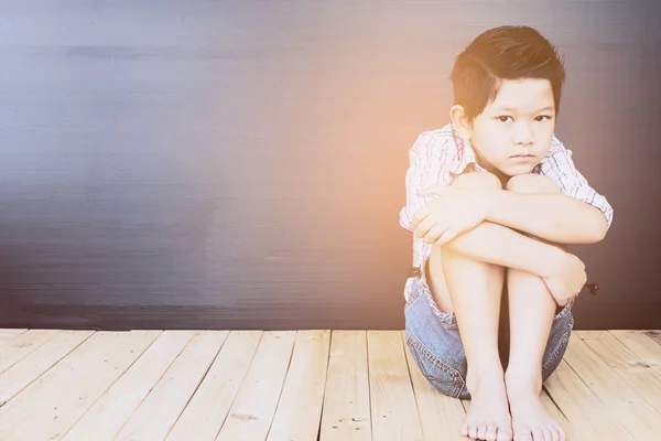 木製の床の上に座って悲しいアジア少年 — ストック写真