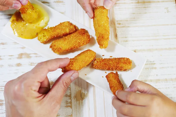 people eating cheese stick many hand eating cheese stick with sauce