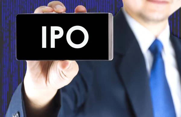 Ipo 株式公開 ぼやけている青年実業家の手とデジタル技術の背景 ビジネス コンセプトで携帯電話の画面上の単語 — ストック写真