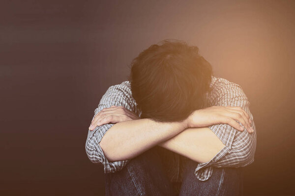 Грустный человек держит голову руками
