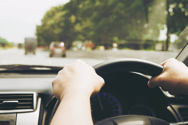 Close up of a man driving car using two hands