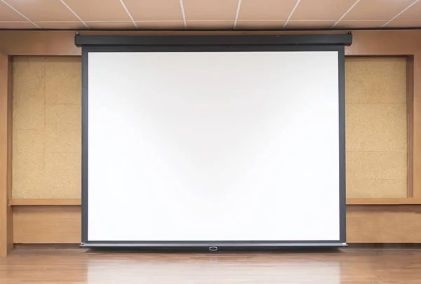 Front view of lecture room with empty white projector screen