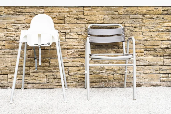 Baby and adult chair with sand stone wall background