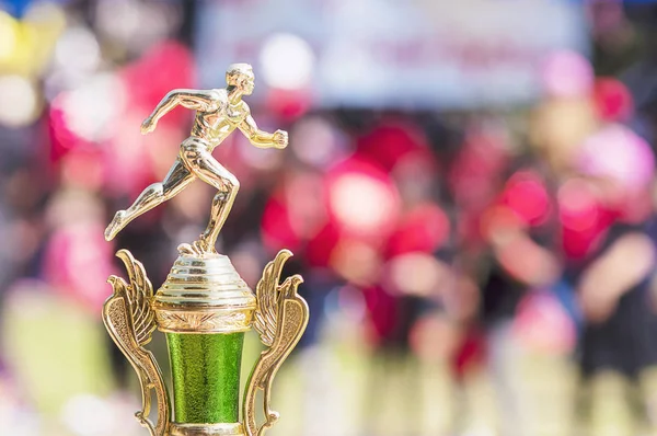 Sport trophy over blur crowded people in school sport day festival