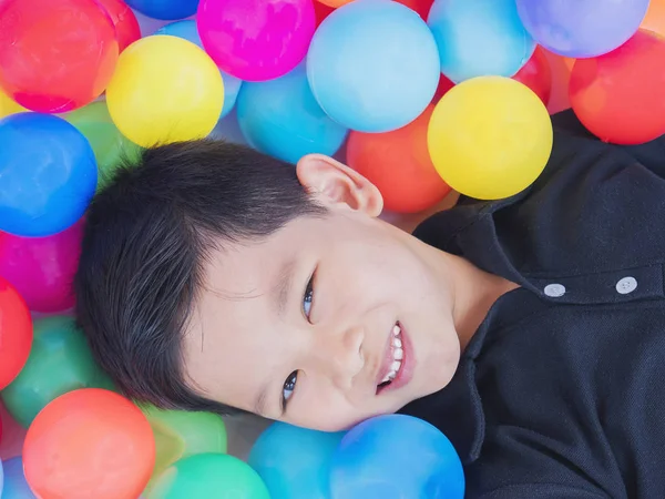 カラフルなおもちゃのボールでアジアに喜んでいる子供 — ストック写真