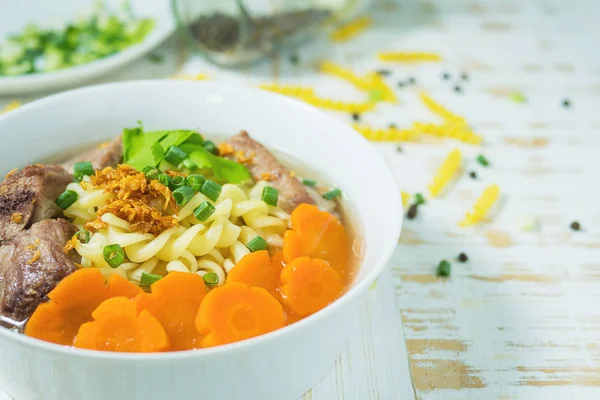 Sopa Macarrão Com Carne Porco Cenoura Mesa Madeira Branca Conceito — Fotografia de Stock