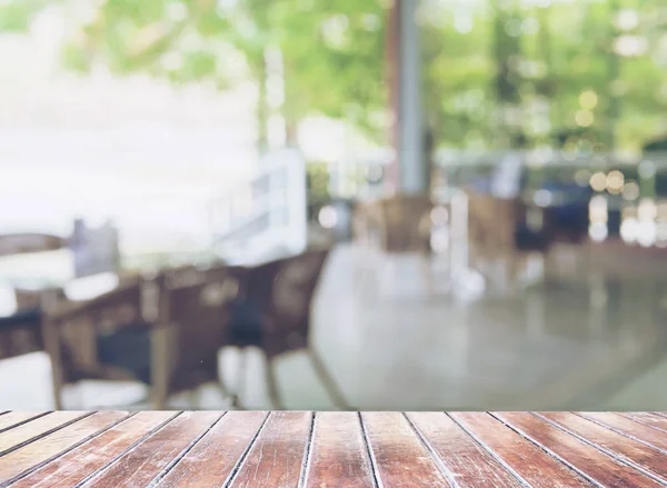 Brown wooden terrace foreground over blurred empty restaurant background