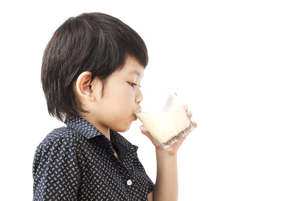 アジアの少年は 白い背景に分離した牛乳のガラスを飲んでいます — ストック写真