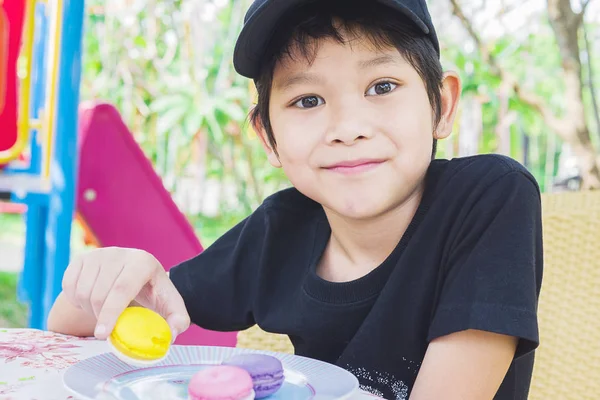 Asiático Chico Comer Macaron Con Patio Fondo — Foto de Stock