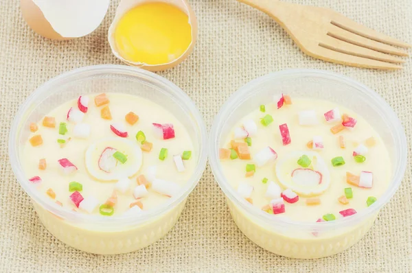 Thai steamed egg with fresh beaten egg and fork decoration on sack background