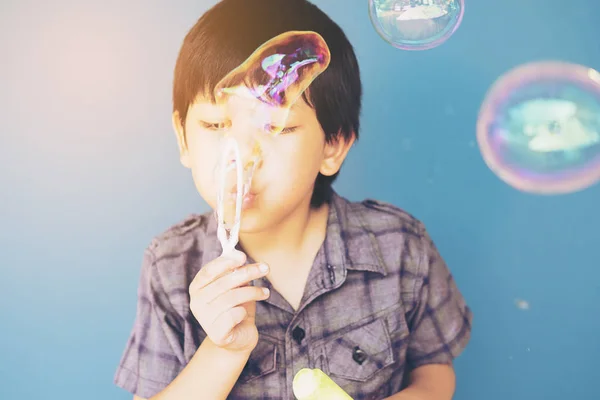 Asiático Chico Soplando Burbujas Sobre Luz Azul Fondo — Foto de Stock