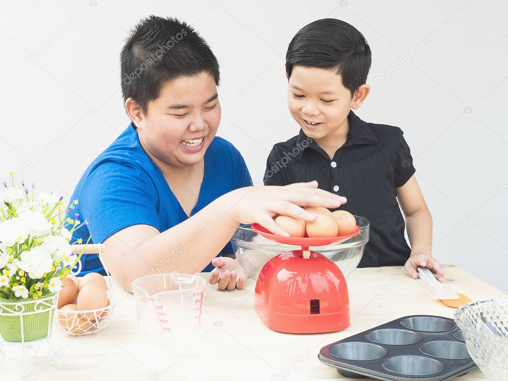 Asian boys making cake