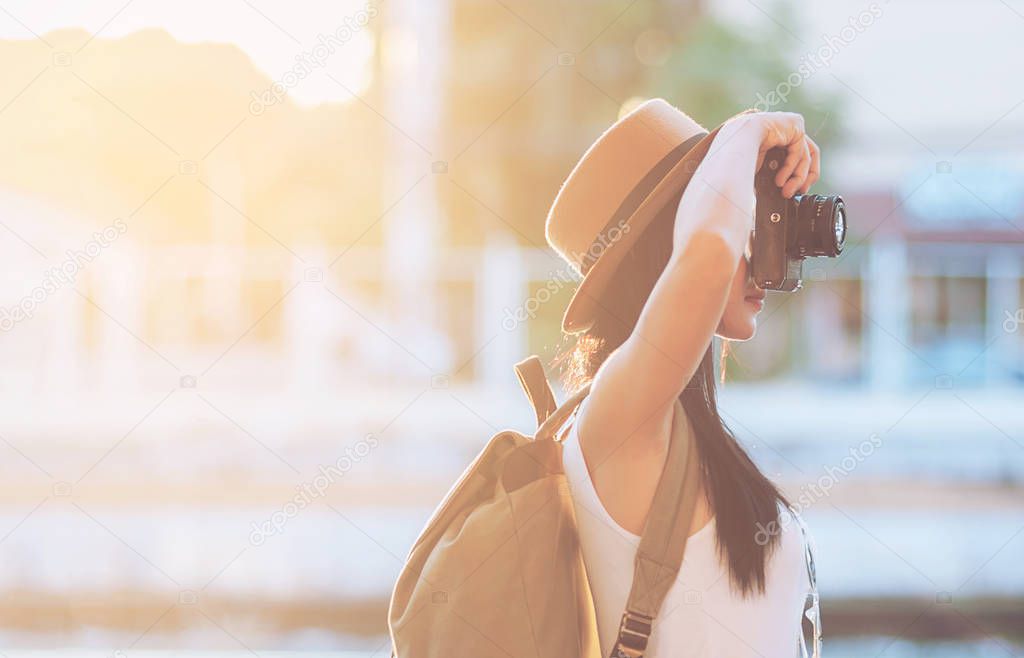 Tourist travel woman shooting camera while walking on a street  - street backpack travel concept