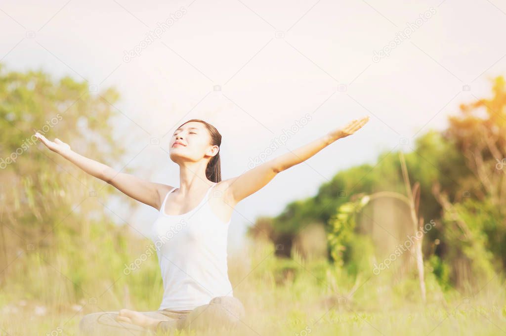 Young lady doing yoga exercise in green field outdoor area showing calm peaceful in meditation mind - people practise yoga for meditation and exercise concept 