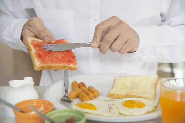 Business man eat the American breakfast set in a hotel - people take a breakfast in hotel concept