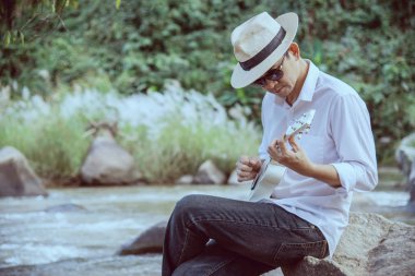Man oyun ukulele nehir-insanlar ve müzik aleti yaşam tarzı yeni doğa kavramı 