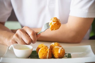 Adam yapışkan streç kızarmış peynir topu yiyecek. Fotoğraf peynir topu odaklanmıştır