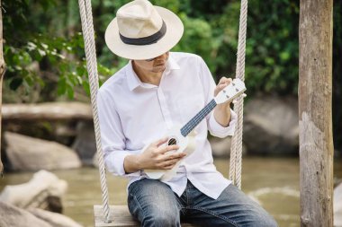 Man oyun ukulele nehir-insanlar ve müzik aleti yaşam tarzı yeni doğa kavramı 