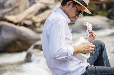 Adam oyun ukulele yeni şelale - yaşam tarzı doğa kavramı içinde insanlar ve müzik aleti 