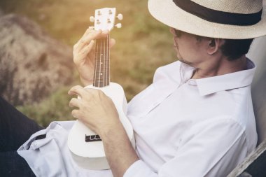 Man oyun ukulele nehir-insanlar ve müzik aleti yaşam tarzı yeni doğa kavramı 