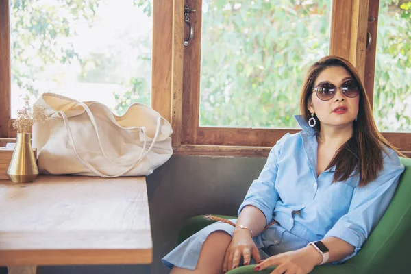 Portrait happy young Asian lady in coffee shop - woman in relax time concept