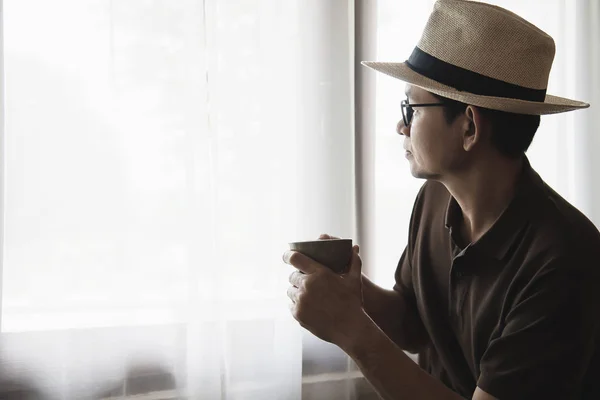 Relax Asian man drink coffee and read book in a modern style coffee shop - people with coffee cup easy lifestyle concept