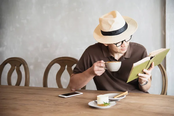 Relax Asian man drink coffee and read book in a modern style coffee shop - people with coffee cup easy lifestyle concept
