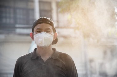 Maske takan adam hava kirliliği ortamında ince tozları korur - hava kirliliği konsepti için koruma ekipmanı olan kişiler