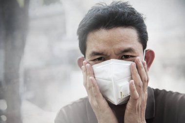 Maske takan adam hava kirliliği ortamında ince tozları korur - hava kirliliği konsepti için koruma ekipmanı olan kişiler