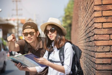 Asya sırt çantası çift turist şehir haritası tutan yol geçiş - seyahat insanlar tatil yaşam tarzı kavramı