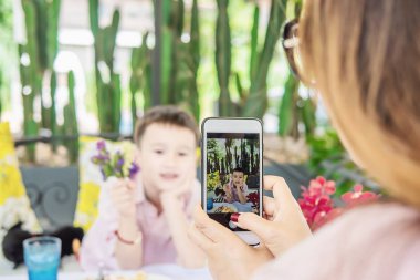 Anne cep telefonu kullanmak restoranda oğlunun bir fotoğraf çekmek - aile yaşam tarzı anne ve oğlu an kavramı zevk