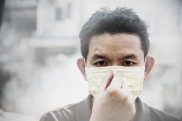 Man wearing mask protect fine dust in air pollution environment - people with protection equipment for air pollution concept