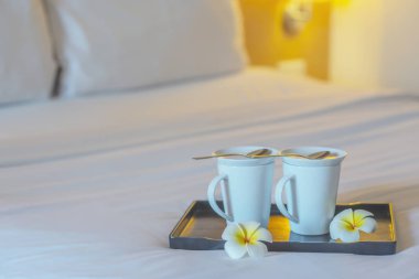 Otel odasında beyaz yatakta ikiz karşılama kahve fincanı yakın - otel iyi misafirperverliği tatil seyahat konsepti