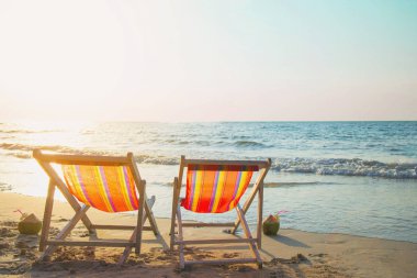 Sıcak günbatımı ile kum plajda Çift dinlenmek sandalye - güzel deniz doğa konsepti tatil 