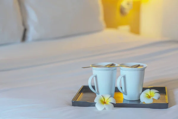 Close up of twin welcome coffee cup on white bed in hotel room - hotel well hospitality vacation travel concept