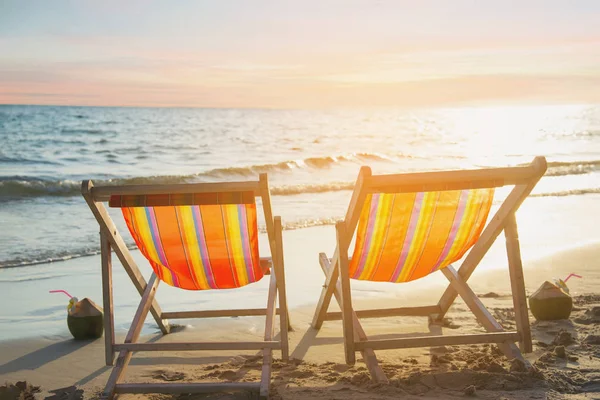 Sıcak günbatımı ile kum plajda Çift dinlenmek sandalye - güzel deniz doğa konsepti tatil