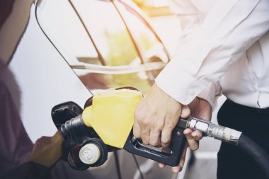 Adam arabasını bir pompa gaz istasyonunda benzin yakıt koyarak