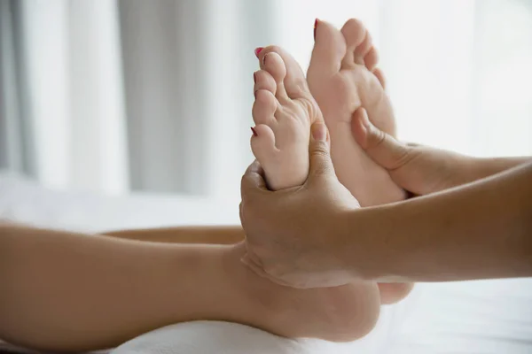 Woman receiving foot massage service from masseuse close up at hand and foot - relax in foot massage therapy service concept