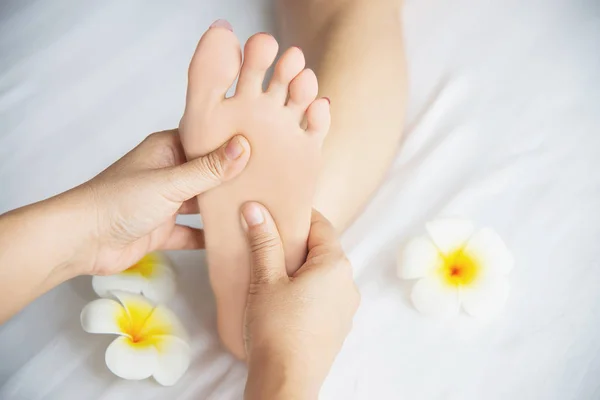 Woman receiving foot massage service from masseuse close up at hand and foot - relax in foot massage therapy service concept