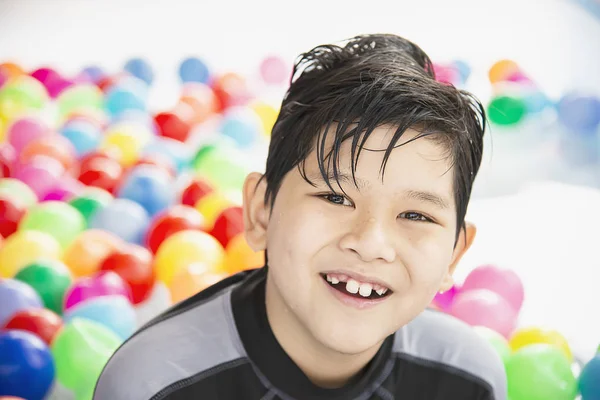 小さなスイミングプールのおもちゃでカラフルなボールで遊ぶ少年 水プールのおもちゃの概念で幸せな少年 — ストック写真