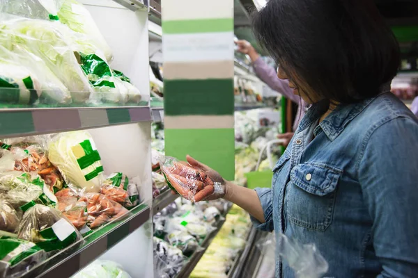 Lady is shopping fresh vegetable in supermarket store - woman in fresh market lifestyle concept