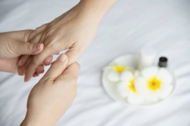 Temiz beyaz yatak arka plan üzerinde el spa masajı - insanlar el masajı hizmeti ile dinlenmek