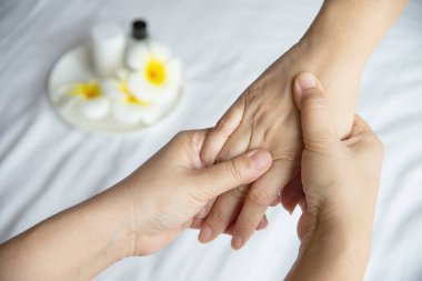 Temiz beyaz yatak arka plan üzerinde el spa masajı - insanlar el masajı hizmeti ile dinlenmek