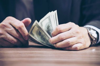 Veznedarın elleri dolar banknotlarını sayıyor. 