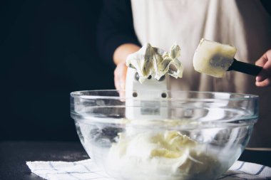 Bayan elektrikli taşınabilir karıştırma makinesi kullanarak kremalı pasta yapıyor.